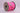 Spool of pink ribbon with candy cane and bow design on a light gray background