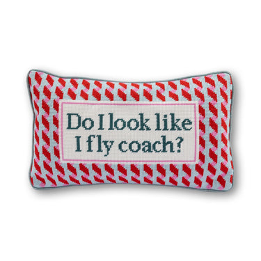 Fly Coach needlepoint pillow front view with ivory text panel, pink and red geometric pattern, and soft blue piping