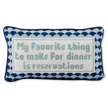 Reservations needlepoint pillow front view with ivory text panel, blue patterned border, and navy piping