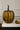 Decorative gold pumpkin and acorn on a book with a white paneled background