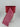 Red and pink heart-patterned ribbon partially unrolled on a white spool