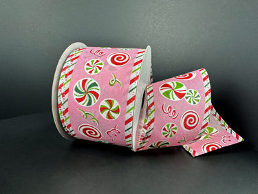 Pink ribbon with candy cane and peppermint pattern on a dark background