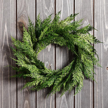 12-inch faux cedar wreath with realistic green branches on rustic wood background