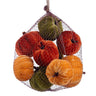 Set of nine assorted velvet pumpkins in orange, rust, golden yellow, and moss green displayed in a mesh bag
