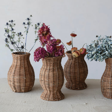 • Natural rattan vases with dried floral stems displayed on a tabletop