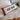 • Good In Bed cotton tufted lumbar pillow styled on a bed