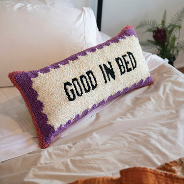 • Good In Bed cotton tufted lumbar pillow styled on a bed