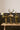 Three gold animal figurines with floral displays on a wooden table against a dark paneled wall.