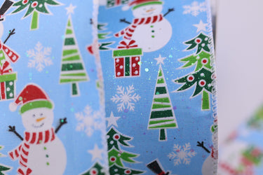 Christmas-themed fabric with snowmen, trees, and presents on a blue background