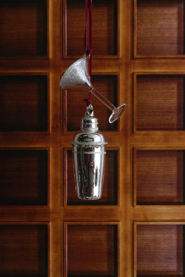 Cody Foster Martini and Shaker Ornament featuring a silver glass cocktail shaker paired with a clear glittered martini glass on a wood background. 