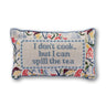 Spill the Tea needlepoint pillow front view with blue text panel, multicolor floral pattern, and light blue piping