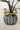 Close-up of gold resin mushroom plant stakes tucked into soil around a potted plant